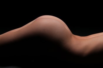 Nude woman’s torso in deep shadow