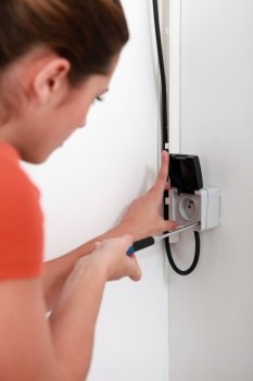 Woman repairing a plug