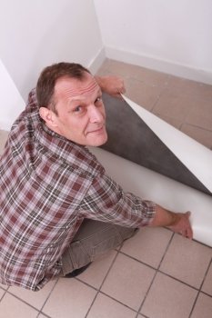 Man unrolling carpet
