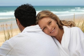 Couple in bathrobes on the beach