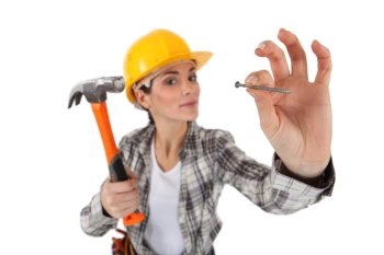 Woman about to hit nail with hammer