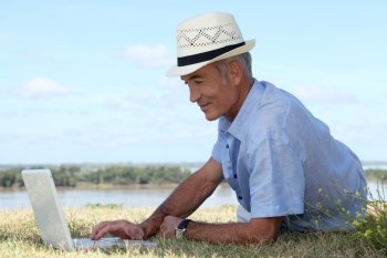 Man with computer at edge of river