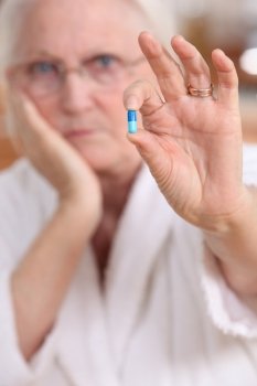 Elderly woman with a pill