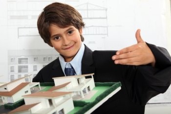 Boy dressed as a businessman in an architect’s office