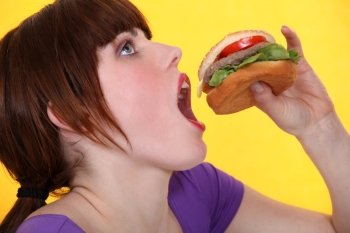 teenager eating hamburger
