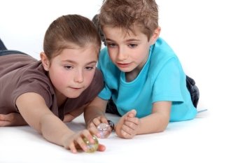 Brother and sister playing with marbles