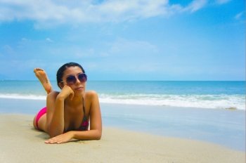 Young woman lying  on beach sun tanning.