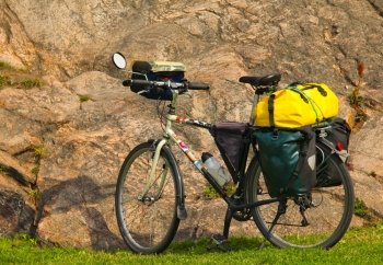 Loaded touring bicycle on rest break, next to a mauntain