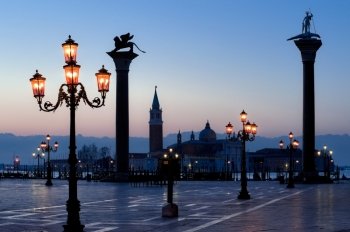 Morning at San Marco square. Morning at San Marco square. Saint Theodore and Lion of Saint Mark columns, and famous Venetian street-lamps. Church of San Giorgio Maggiore at the background.