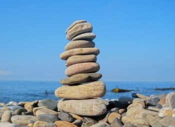 Balanced stones on the seashore summertime and blue sky background