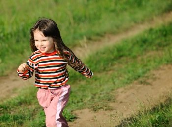 The running girl on a green floor. The happy child on a spring meadow