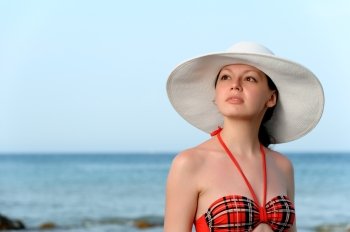 The girl in a hat against the sea and blue sky