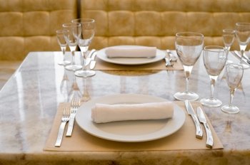 place setting at laid restaurant table in beige colours