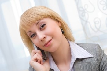 young blonde businesswoman speaks over cell phone