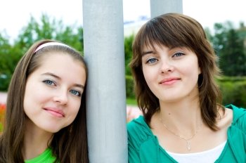 closeup shot of young beautiful smiling european girls at both sides of pole