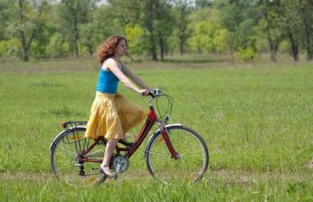 beautiful girl goes by bicycle