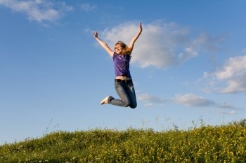 Jumping girl on the green meadow 