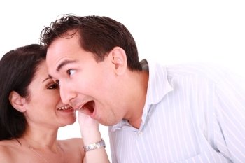 girl tells something into surprised guy’s ear isolated on white background