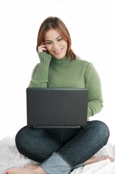 woman talking on mobile phone in front of laptop 