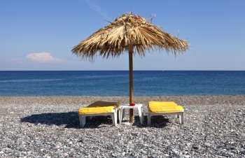 Two beach chair and umbrella at Aegean sea shore