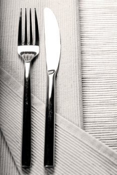 Vintage knife and fork on linen napkin sepia toned