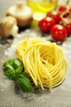 Fresh pasta and italian ingredients on wooden board