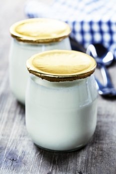 Sour cream or natural yogurt with spoons - health and diet concept
