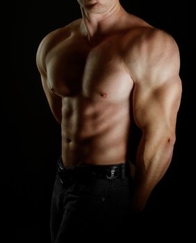 bodybuilder posing. Handsome power athletic guy male. Fitness muscular body on black background. 