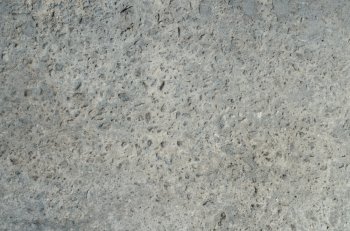Grey industrial concrete texture with small stones.