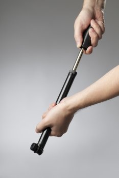 A compact hand-operated black plastic bicycle pump