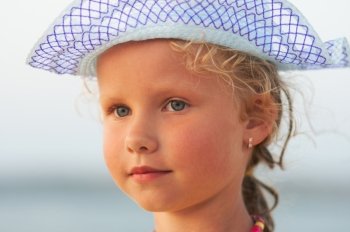 Small girl evening outdoor portrait in hat