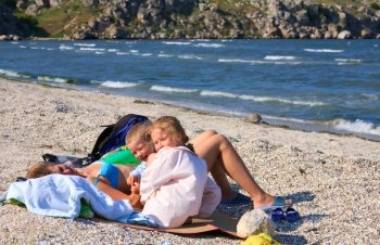 happy family (mother with small children) relax on beach