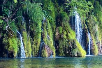 Summer view of beautiful small waterfalls and clear lake in front  (Plitvice Lakes National Park, Croatia)