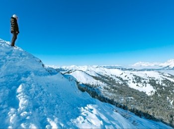 Woman  on winter mountain Shneeberg top and view behind (Hochkoenig region, Austria)