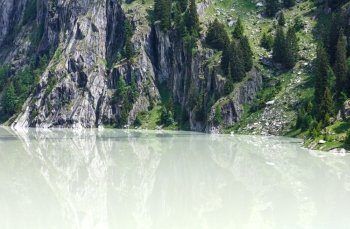 Lake  with turbid water formed the dam. Summer mountain landscape (Alps, Switzerland)