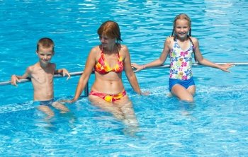 Mother with her children in the summer outdoor pool.