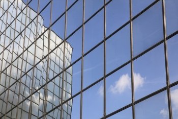 reflection of cloud and blue sky in glass facade