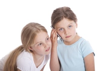 two young girls with mobile phone against white background
