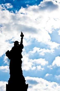 Sunnny day, blue sky with clouds: statue of Liberty with copy space