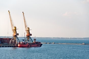 Port cranes in port. In the background is the coastline of the city. Odessa, Ukraine.