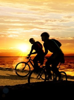 Couple on bicycles on the brink of a rock near sea