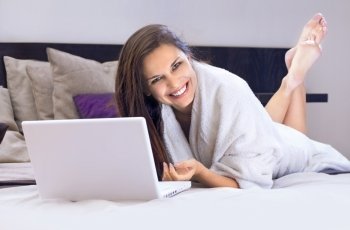 happy business lady on the bed with laptop