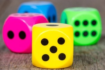 Close-up colorful dice on the  wooden background