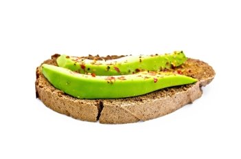 A slice of rye bread with slices of avocado and pepper isolated on white background