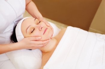 Close-up shot of a woman getting facial massage at beauty treatment salon