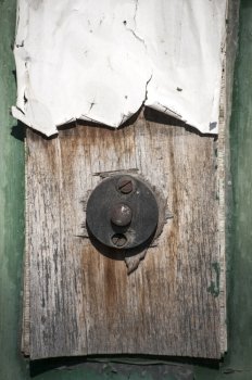 Old weathered grunge doorbell button on wooden plate