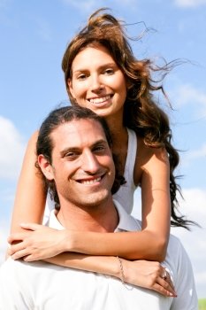 Young lady embracing her man and smiling at camera