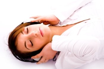side pose of woman lying down on floor tuned to music against white background