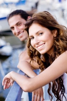Smiling lady and guy posing on footbridge while facing camera