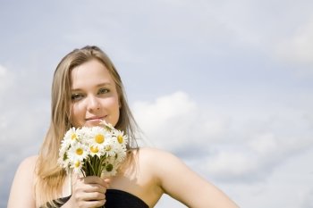 Happy Day. Young Woman With Flowers Under The Cloudscape.